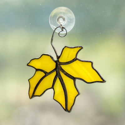 Yellow stained glass suncatcher of a yellow maple leaf