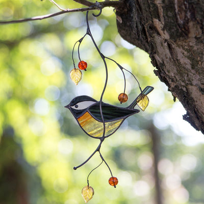 Stained glass black chickadee suncatcher hanging on the branch