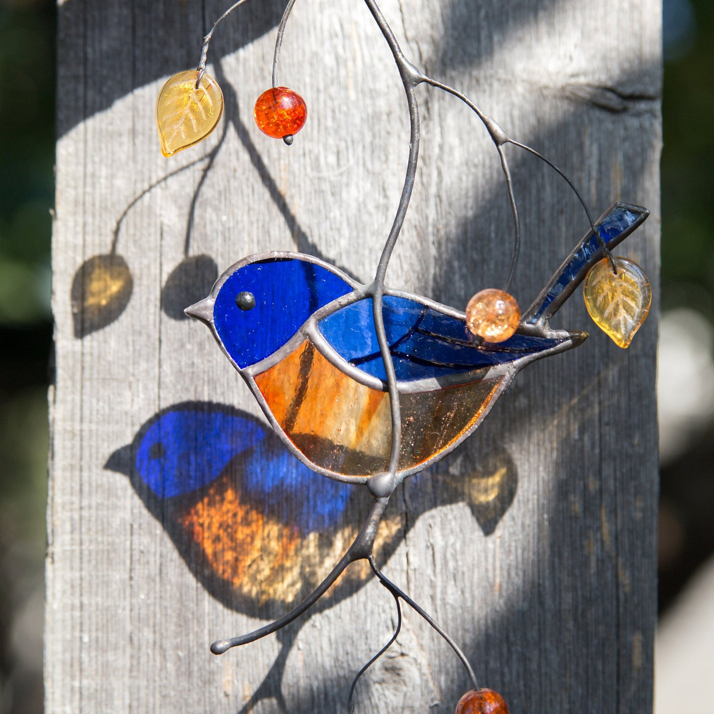 Zoomed stained glass bluebird on the branch suncatcher