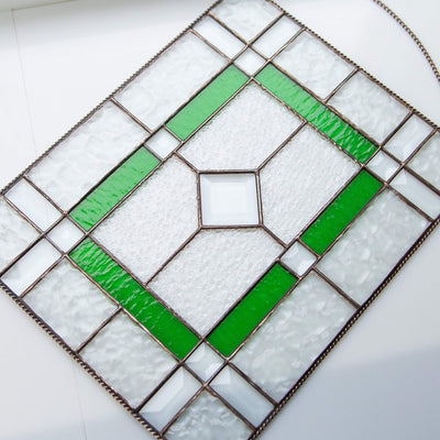 Clear panel of stained glass with green and beveled inserts 