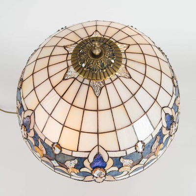 Top view of stained glass lamp shade of beige colours with blue inserts