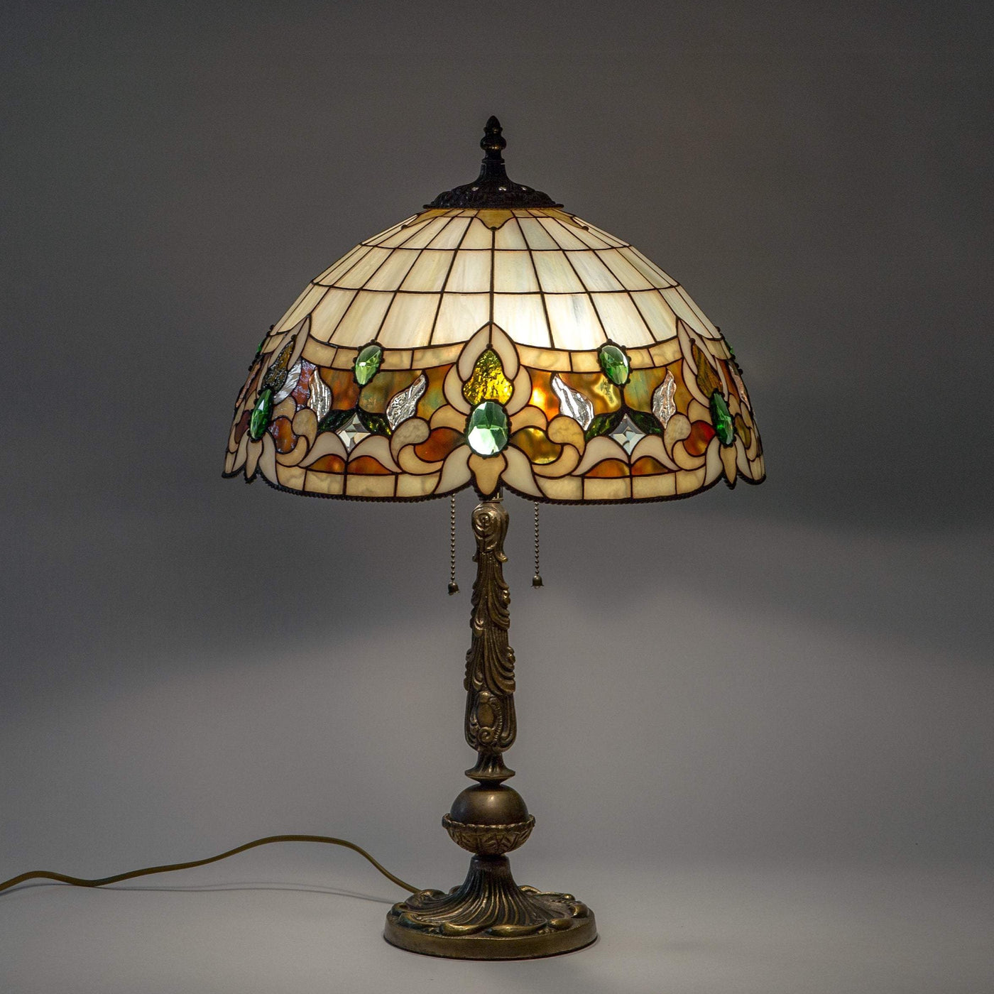 Lit stained glass Tiffany lamp in beige colour with green inserts