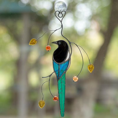 Stained glass colourful magpie sitting on the branch suncatcher