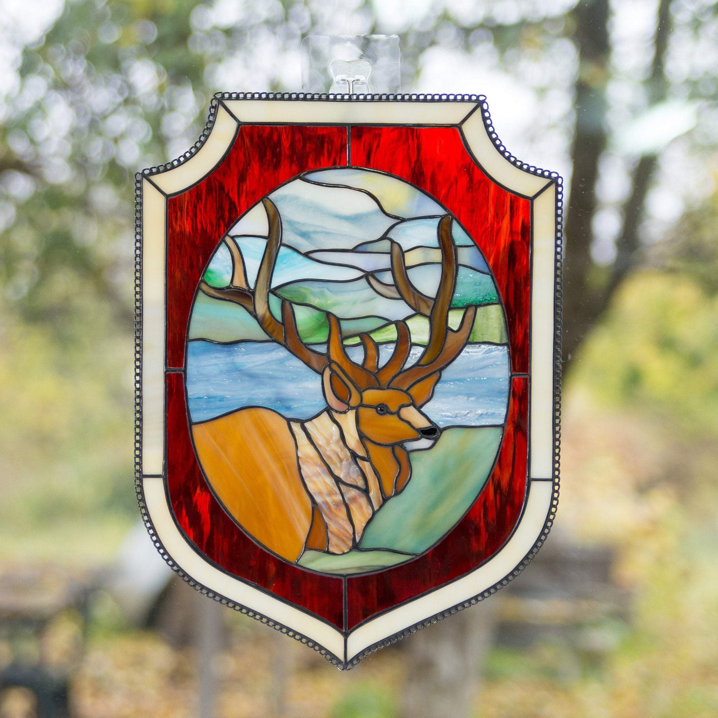 Stained glass deer in the forest environment panel with red and beige frames 