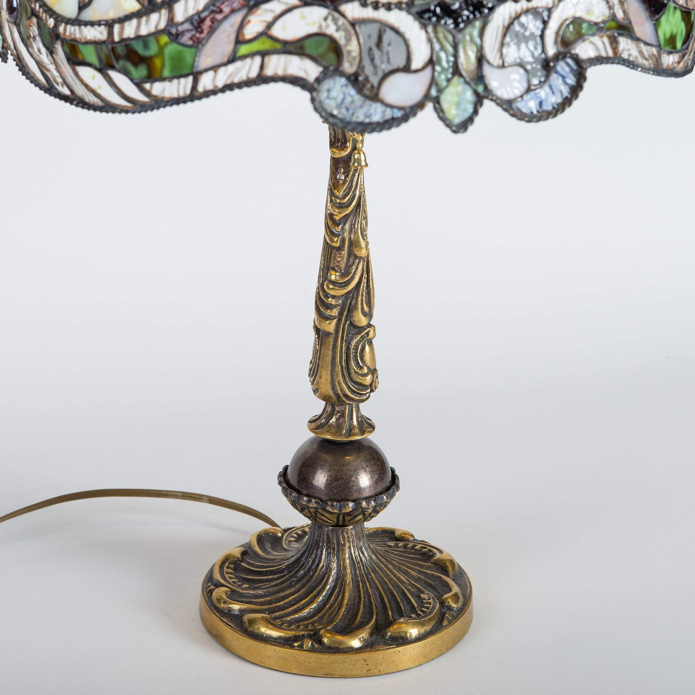 Bronze engraved base of Tiffany green stained glass lamp