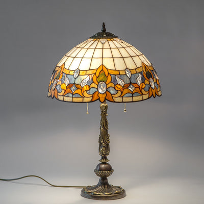 Lit stained glass Tiffany lamp of beige and blue colours