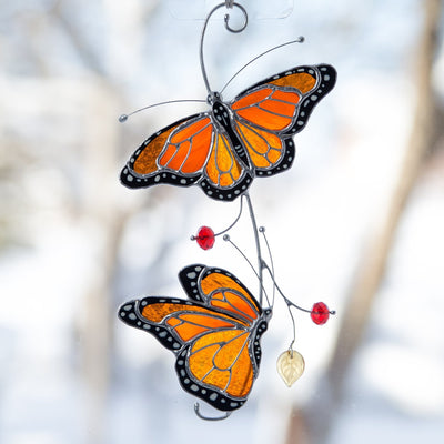 Suncatcher of stained glass monarch butterflies on the branch 