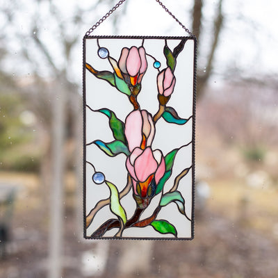 Stained glass magnolia flowers with beveled inserts on the white background panel