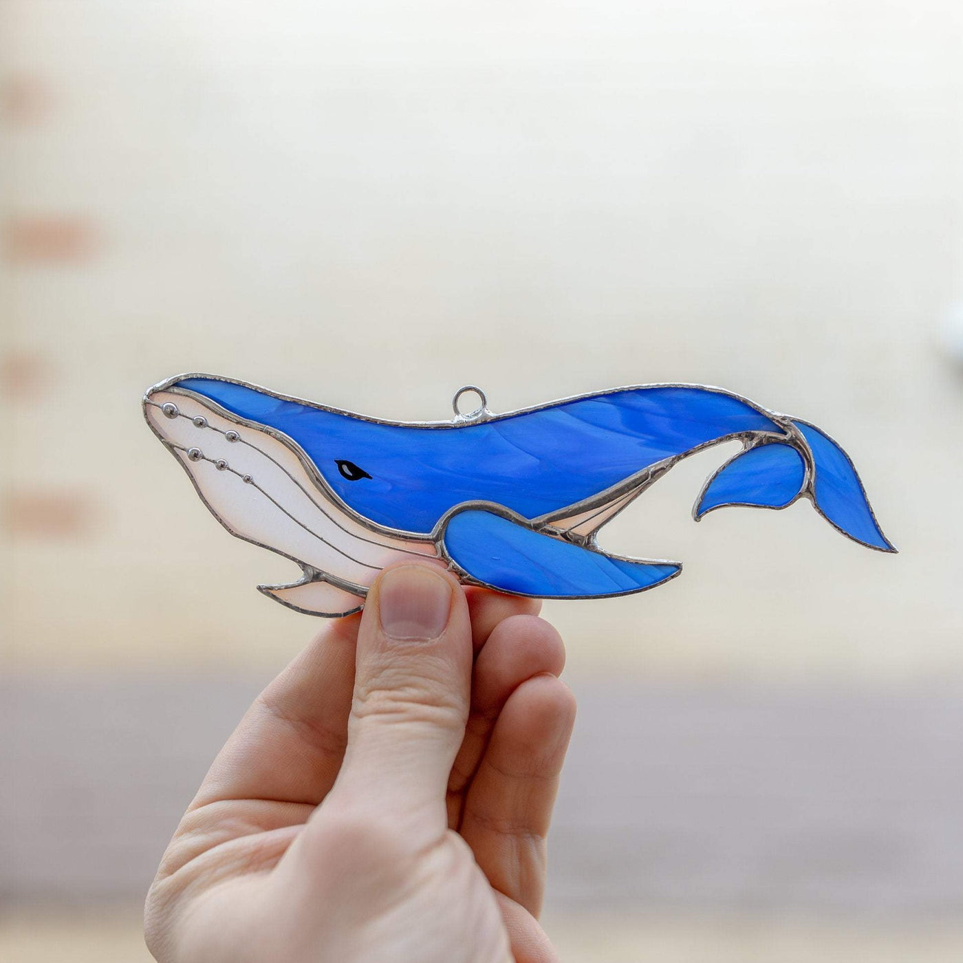 Stained glass royal blue whale with the tail down suncatcher
