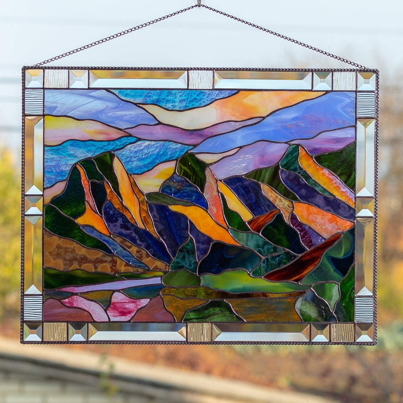Stained glass panel depicting Three Sisters Mountains with sky of different shades