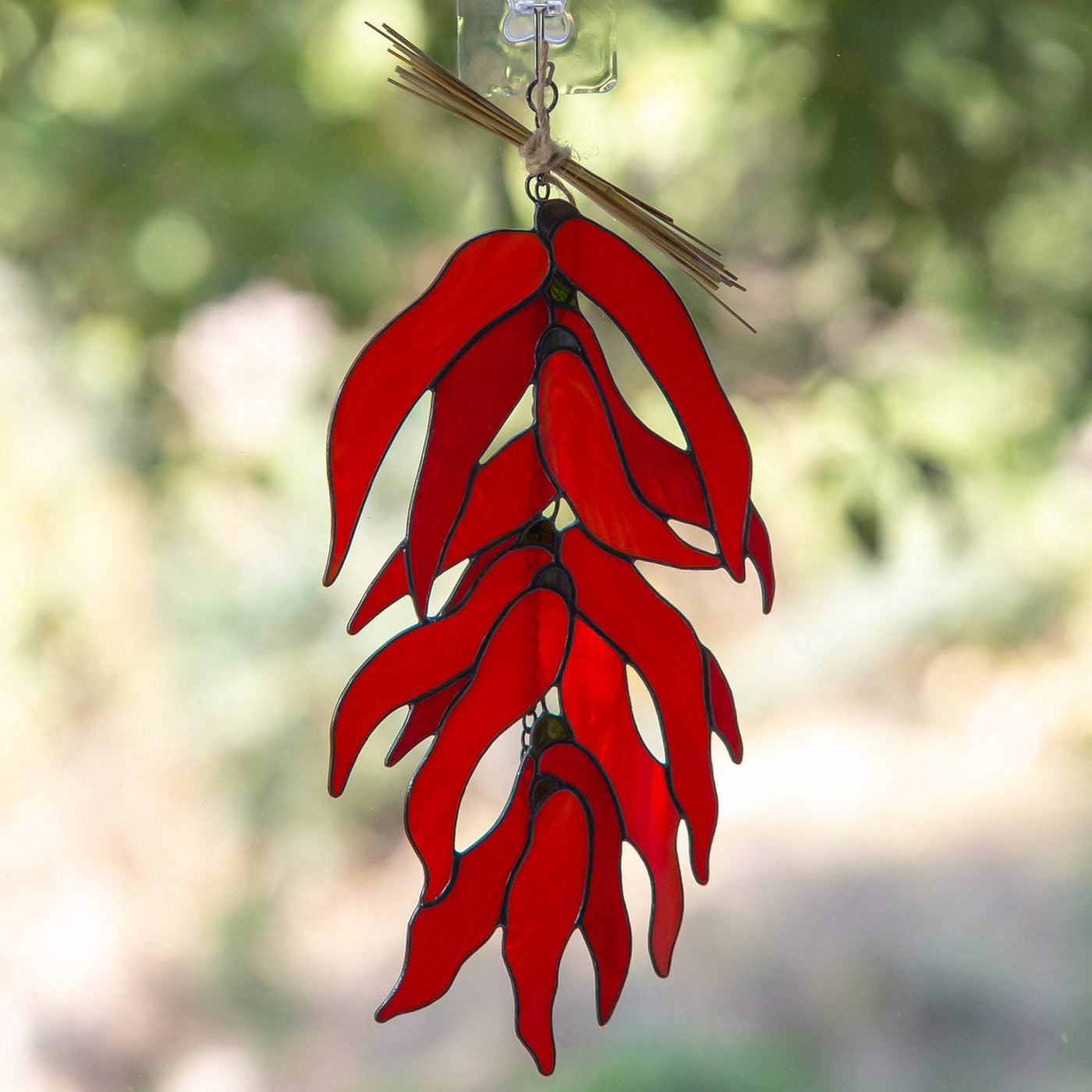 Window hanging of a stained glass ristra chilli peppers 