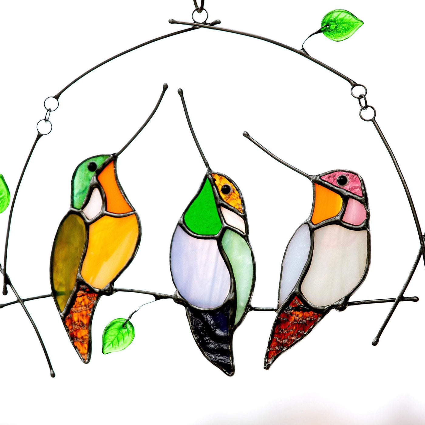 Three zoomed stained glass hummingbirds sitting on the horizontal branch suncatcher