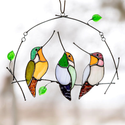 Sitting on the horizontal branch with leaves stained glass hummingbirds window hanging