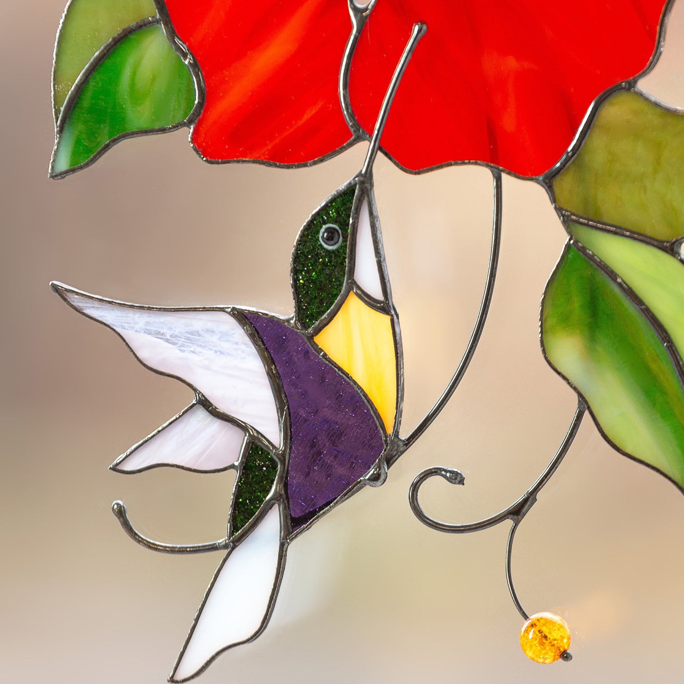 Zoomed hummingbird flying to the red flower stained glass suncatcher
