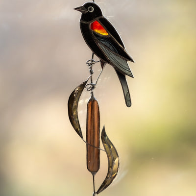 Stained glass red-winged blackbird sitting on the reeds window hanging