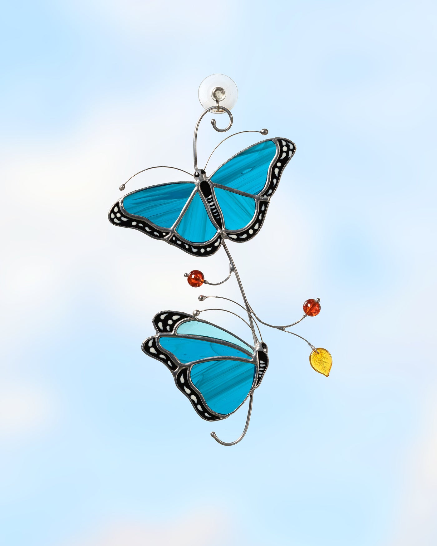 stained glass suncatcher of Blue Morpho butterflies on the branch