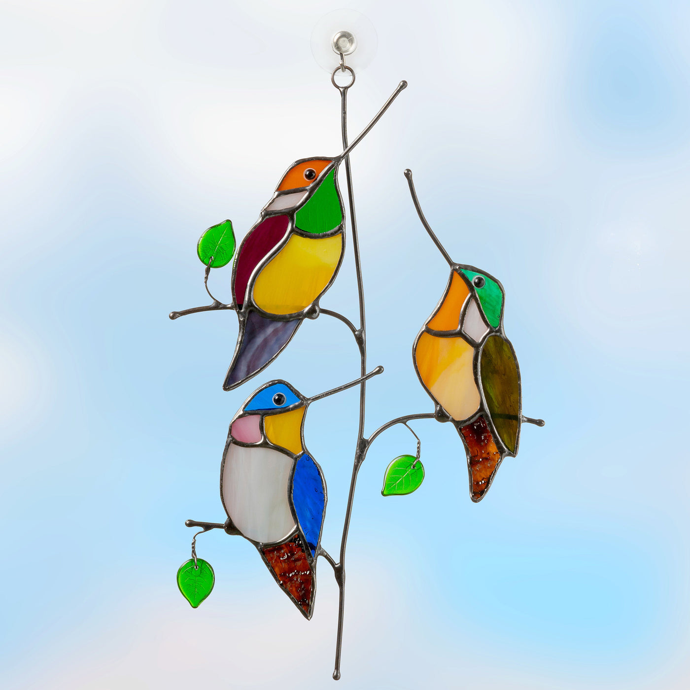 Suncatcher of three stained glass hummingbirds on the vertical branch 