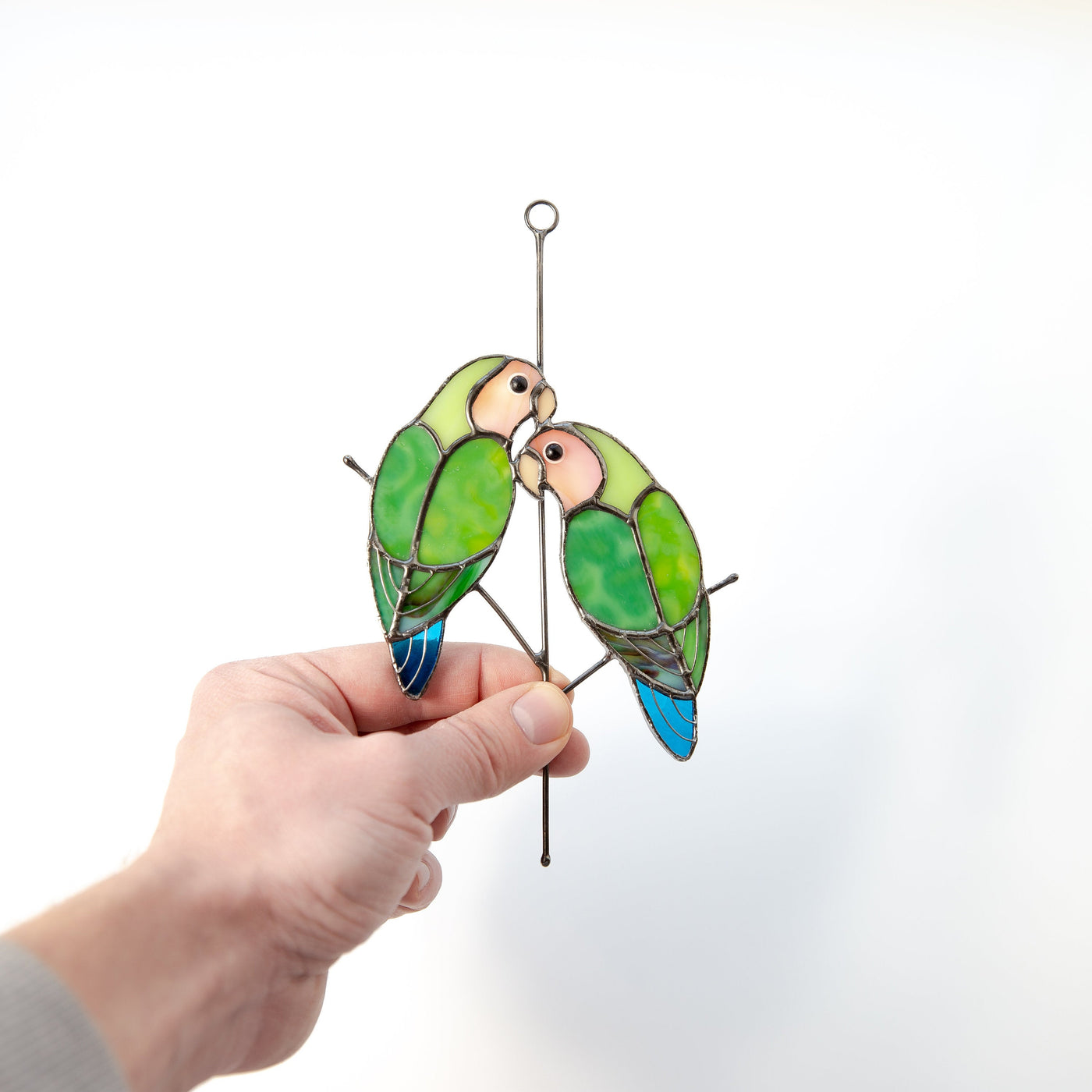 Stained glass pair of lovebirds sitting on the vertical branch suncatcher