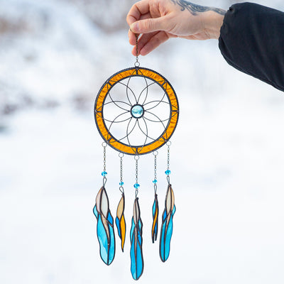 Stained glass dreamcatcher with blue feathers below 
