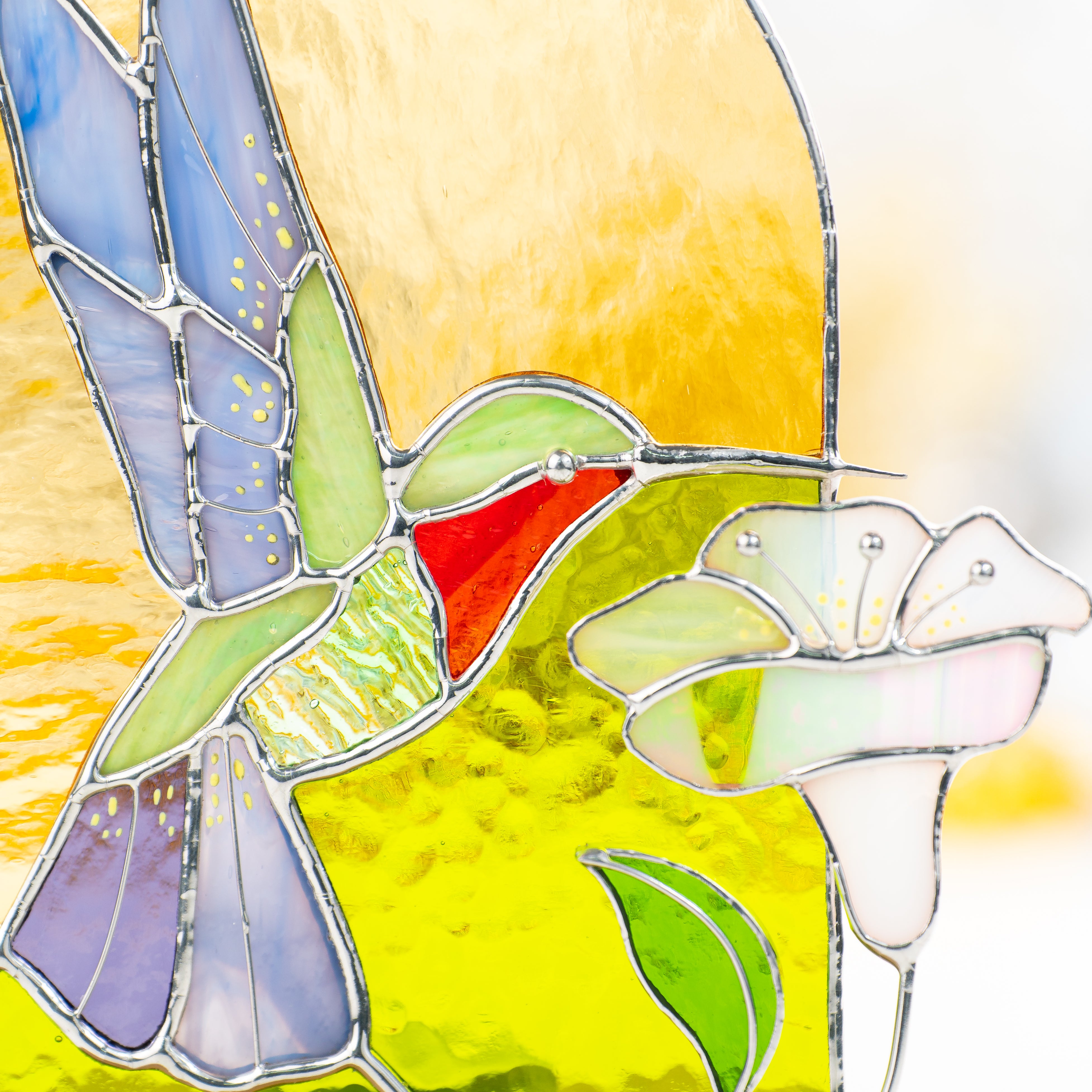 Zoomed stained glass hummingbird depicted on a panel