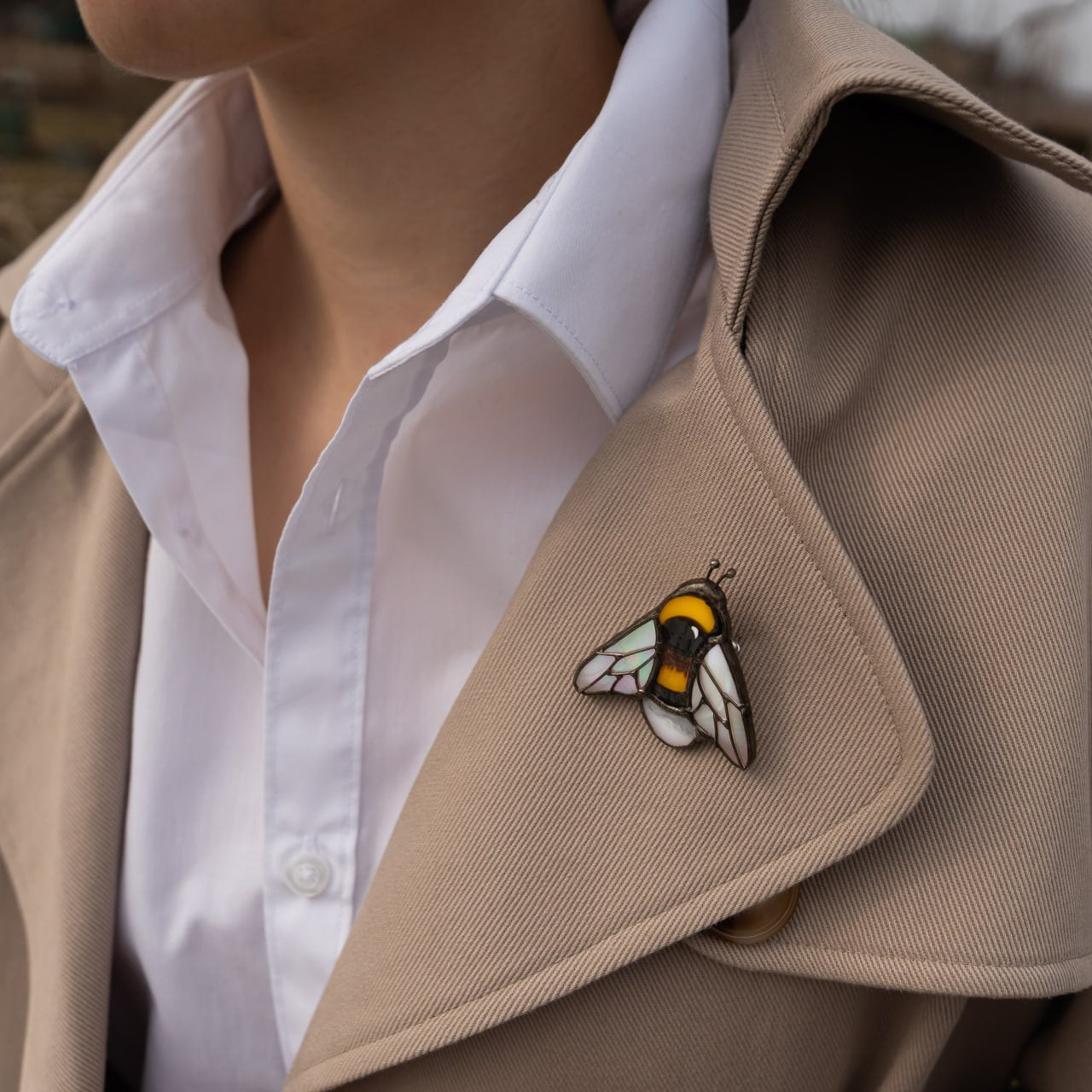 Stained glass bumble bee brooch on a camel coat