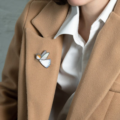 Stained glass angel brooch on a camel coat